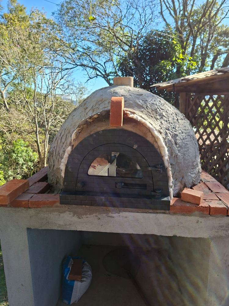 Porta de ferro com visor de vidro encaixada na boca do forno